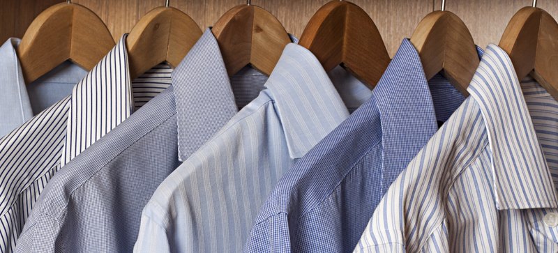 Blue patterned shirts on wooden hangers